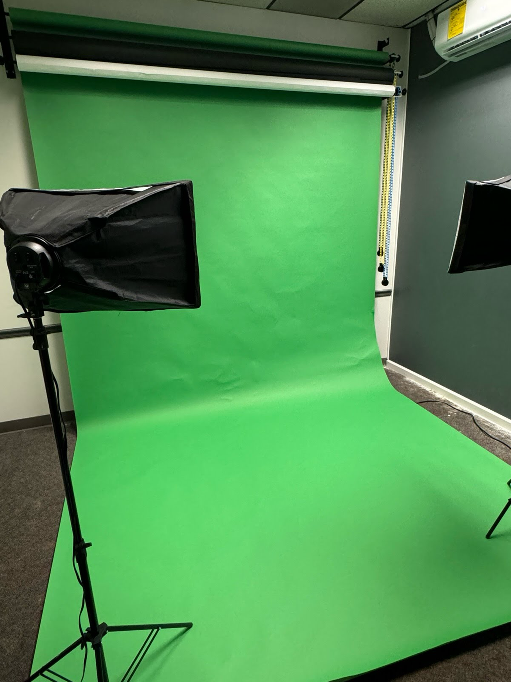Green screen media studio at PAD 2 with lighting, camera setup, and production equipment for photo and video shoots